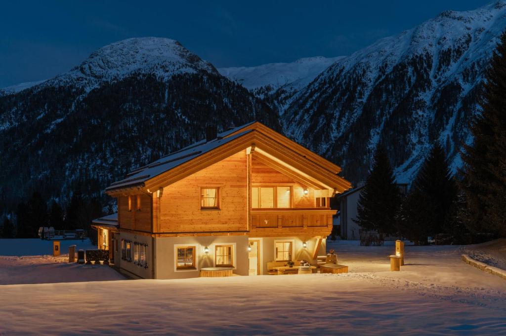 贝韦Engadin Chalet - Private Spa Retreat & Appart -St Moritz - Val Bever的雪中的一个圆木房子,背景是群山