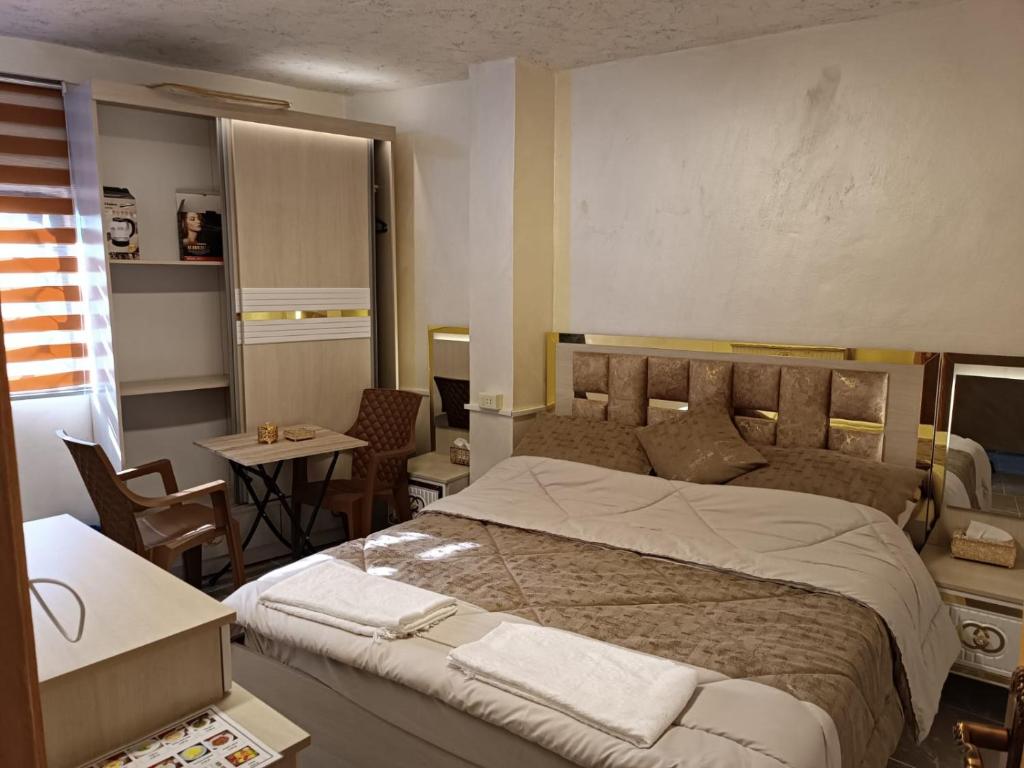 卡拉克hostel ـ Karak dream的一间卧室配有一张大床和一张桌子及椅子