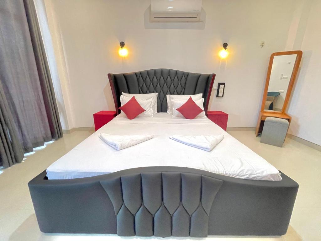 阿努拉德普勒ismattha hotel的一间卧室配有一张带红色枕头的大床