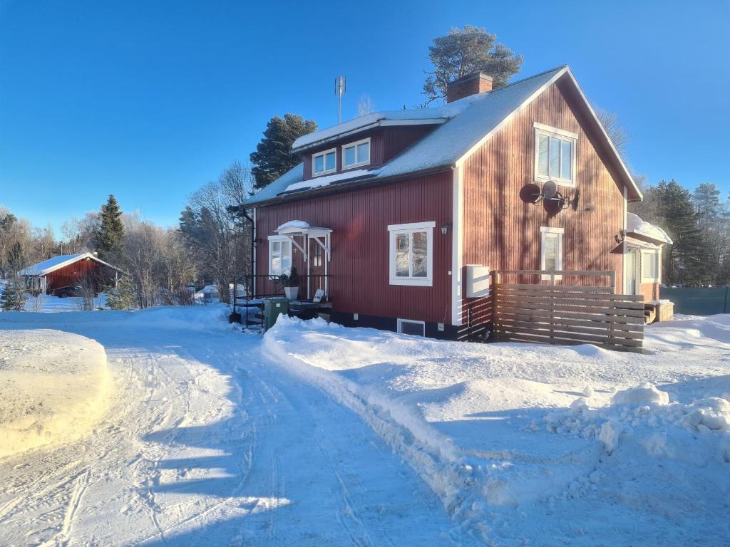 Mattmar vila的一座红色的房子,地面上积雪