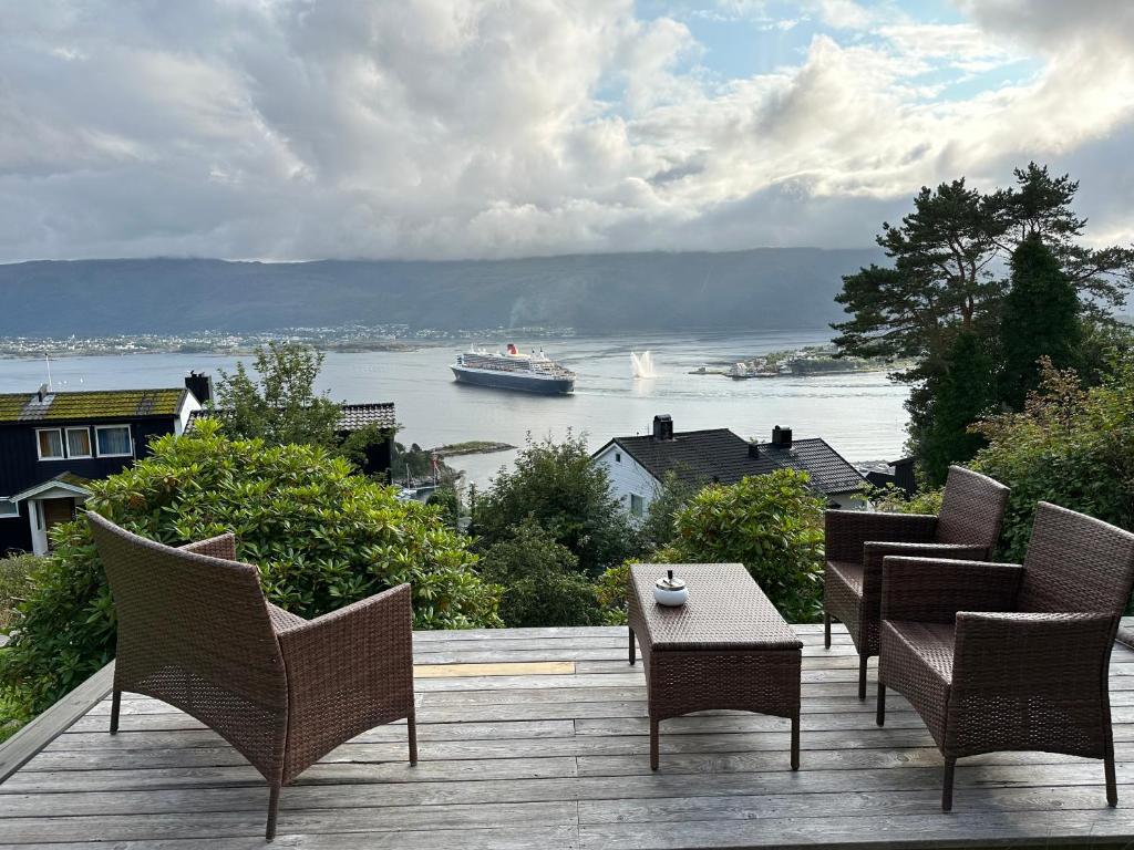 奥勒松Great place with view to the mountains and fjord的水中带椅子和船只的甲板