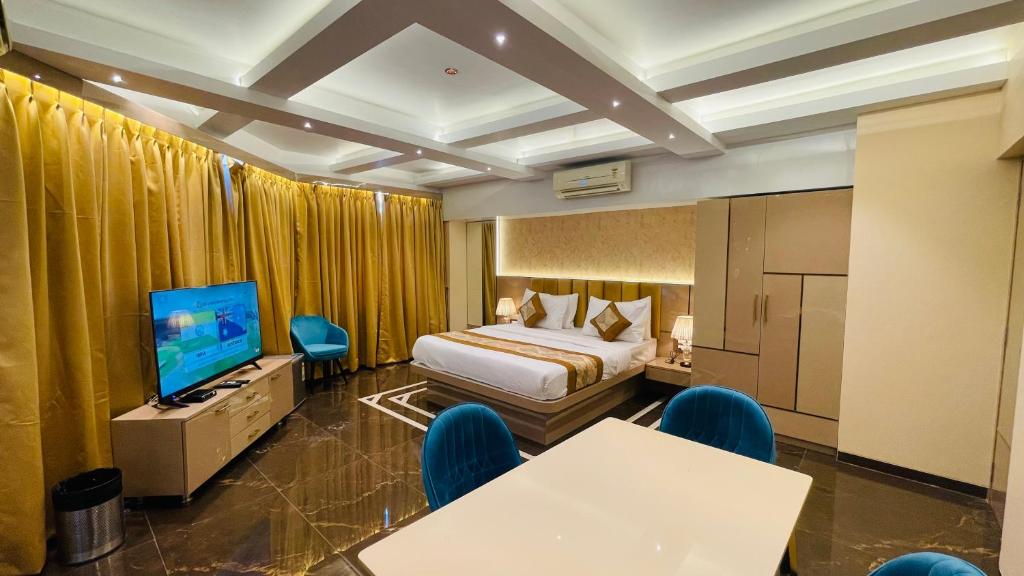 孟买Home2 Renaissance Club的配有一张床和一台平面电视的酒店客房