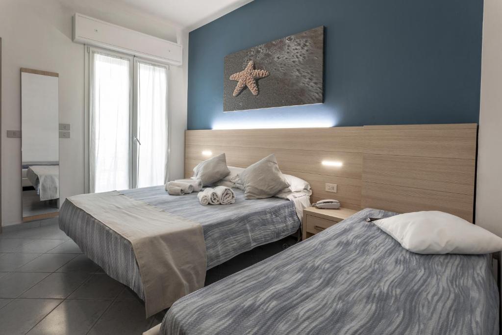 卡托利卡Hotel Esperia的蓝色墙壁客房的两张床