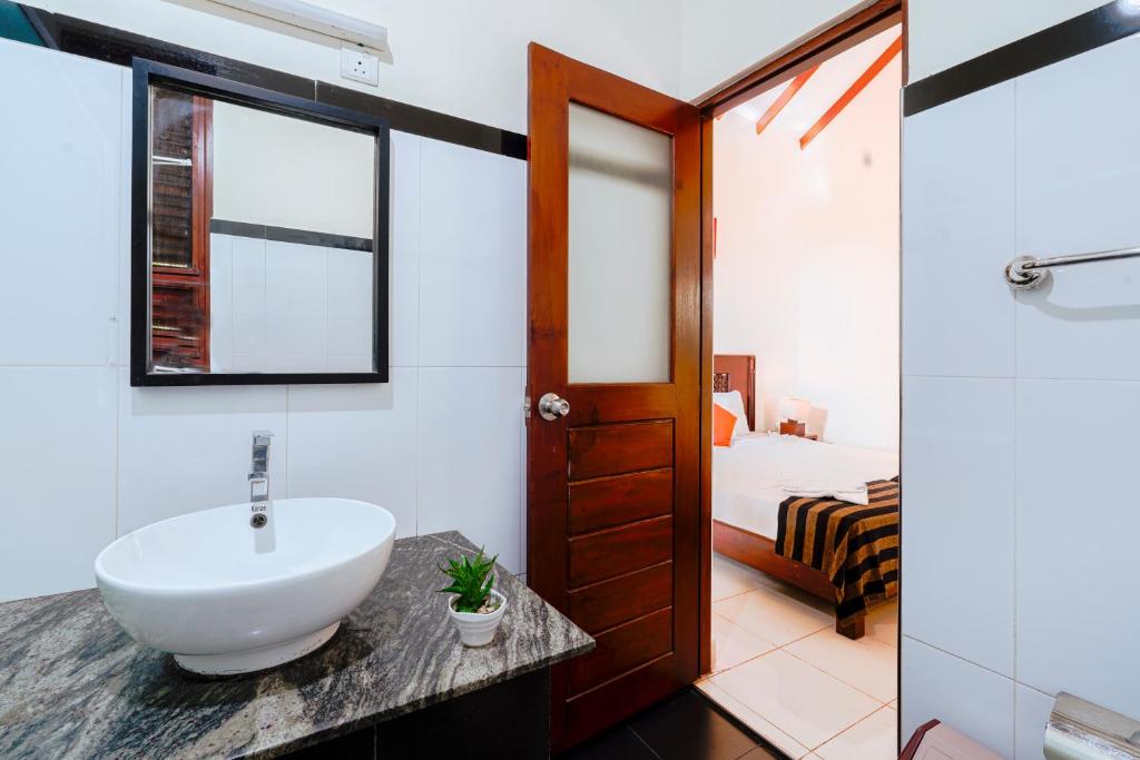 卡特勒格默Safari Lodge Yala的一间带水槽的浴室和一间卧室