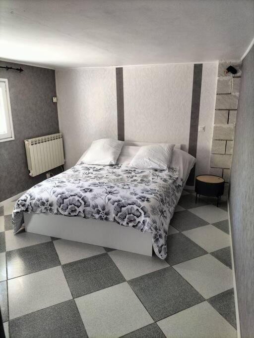 艾格-莫尔特Charmant appart avec extérieur的一间卧室配有一张床,铺有一个 ⁇ 板地板