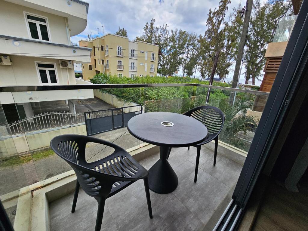 弗利康弗拉克Beachfront Coziness的阳台配有一张桌子和两把椅子,