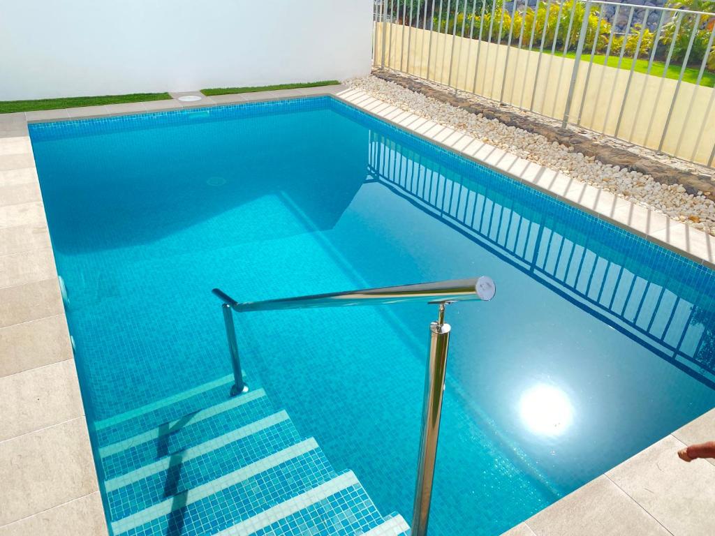 阿德耶OH LA LIFE! MAGNOLIA GOLF SUSANA的蓝色的游泳池,设有楼梯