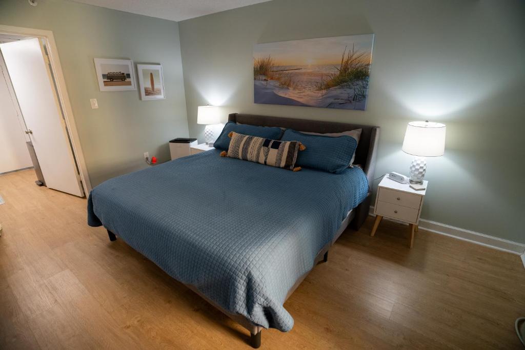 默特尔比奇Sunny Seaside Escape Perfect for Couples的一间卧室配有一张带蓝色棉被的床