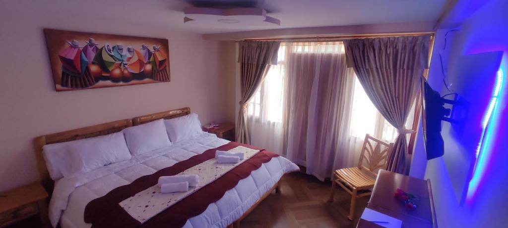 奥塔瓦洛Hospedaje La Joya的一间卧室设有一张床和两个窗户。