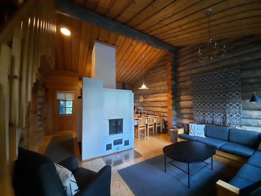 库萨莫Lumi - kelohirsimökki Rukalla, log cabin at Ruka的客厅设有蓝色的沙发和壁炉