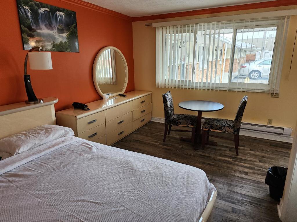 利明顿圣帕洛汽车旅馆的一间卧室配有一张床、一张桌子和一面镜子