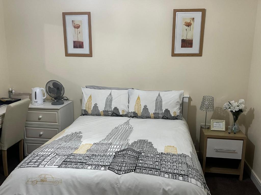 伯明翰HAMS REST PLACE - Strictly Only ONE GUEST ALLOWED IN ONE ROOM A SECOND ACCOMPANYING PERSON WILL NOT BE ALLOWED INTO THE PROPERTY的一间卧室,配有一张带城市图纸的床