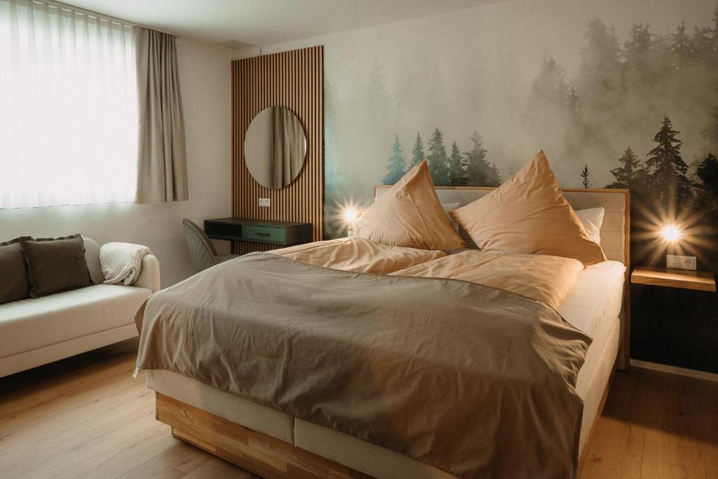 GerabronnBoutique Hotel Haus Marie的一间卧室配有一张床、一张沙发和一面镜子