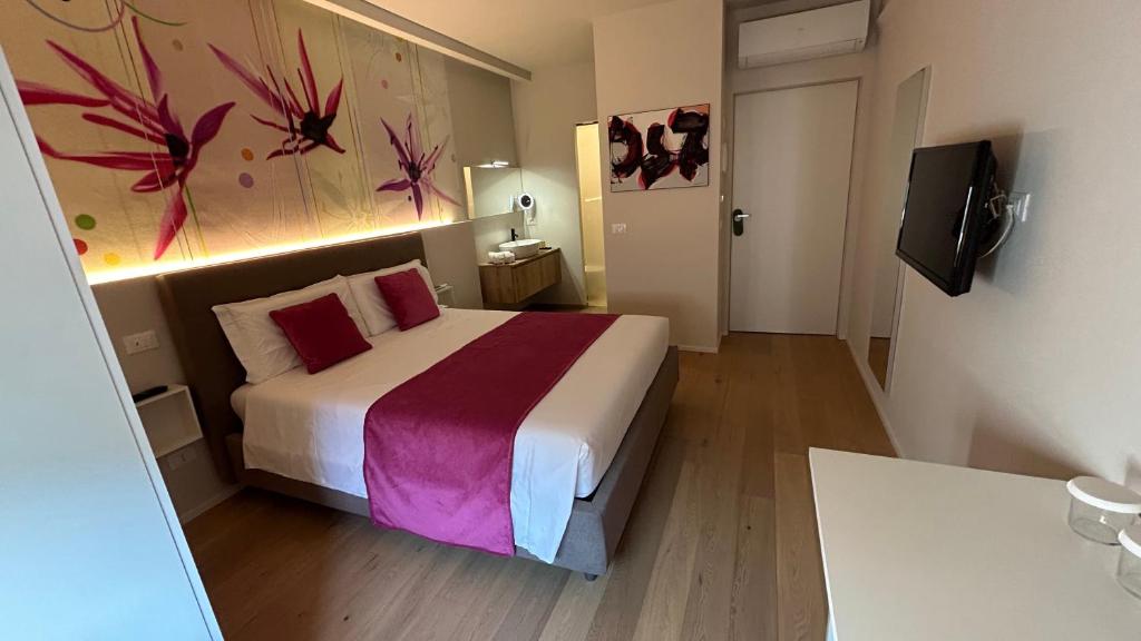 曼托瓦SAN LORENZO Luxury Boutique的卧室配有一张床,墙上挂有绘画作品