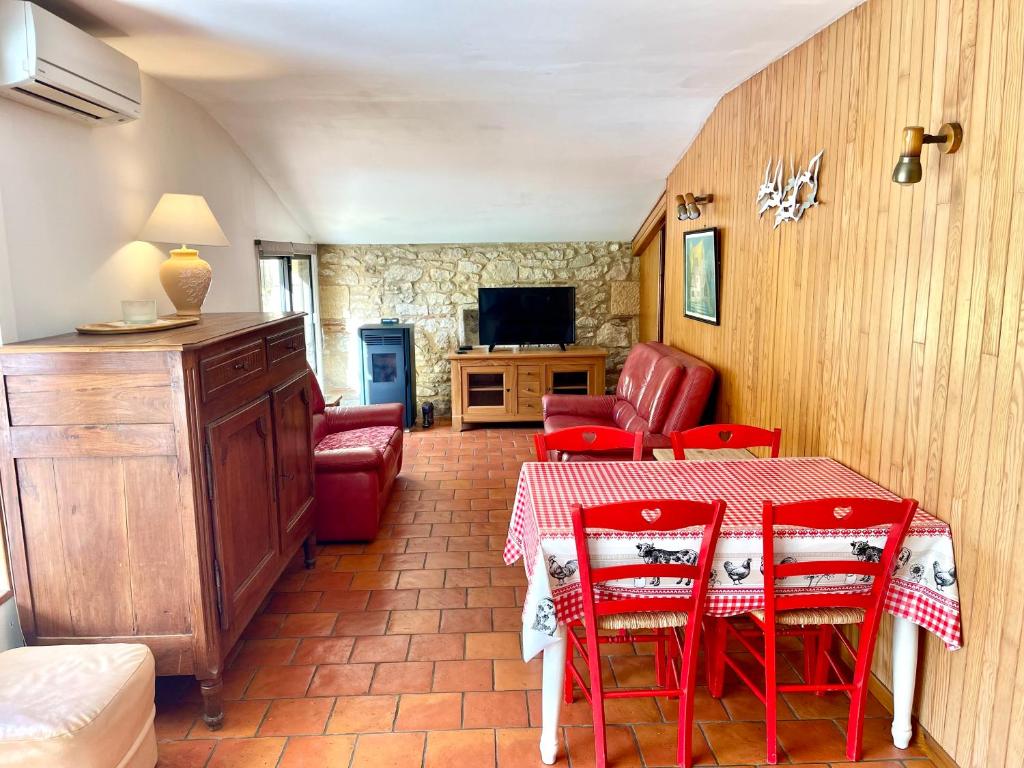 GardonneGite de charme en pierres apparentes : Les Granges的一间带桌子和红色椅子的用餐室