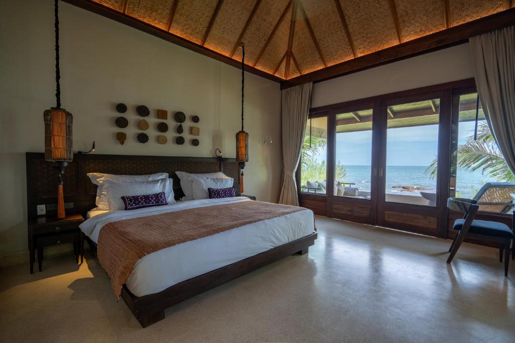 沙美岛Samed Tamarind Beach Resort的一间卧室设有一张床,享有海景