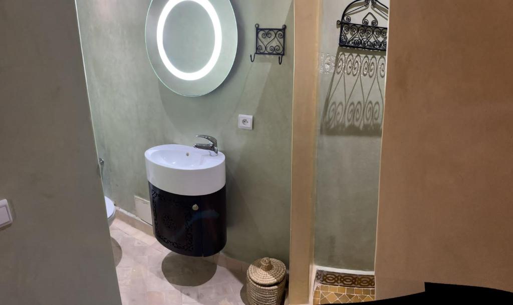 马拉喀什RIAD LAICHI的一间带水槽和圆镜子的浴室