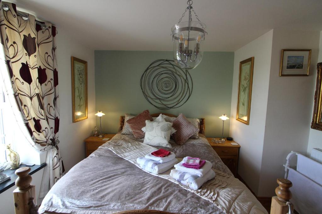 卡姆尔福德Melorne Farm Guest House的一间卧室配有带毛巾的床