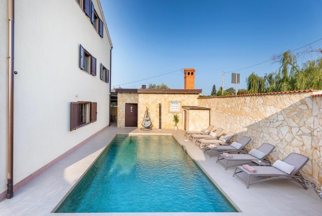 普拉Villa Miromar的一个带躺椅的游泳池以及一座房子