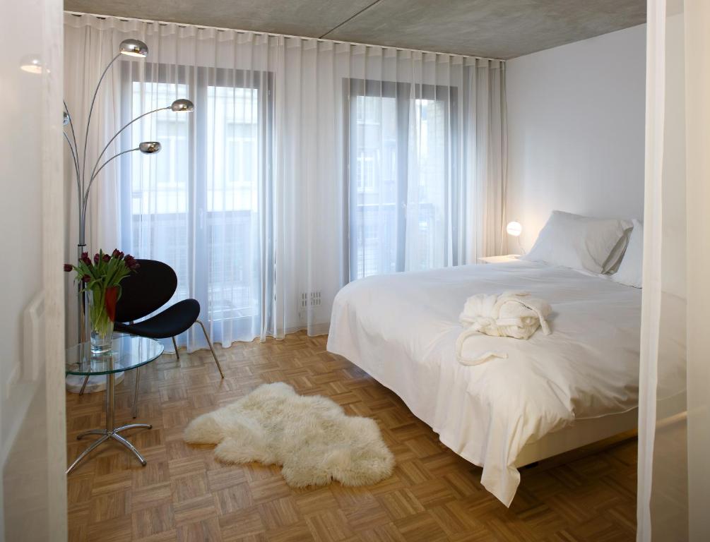 安特卫普BANKS Antwerp的卧室配有白色的床,上面放着一只狗