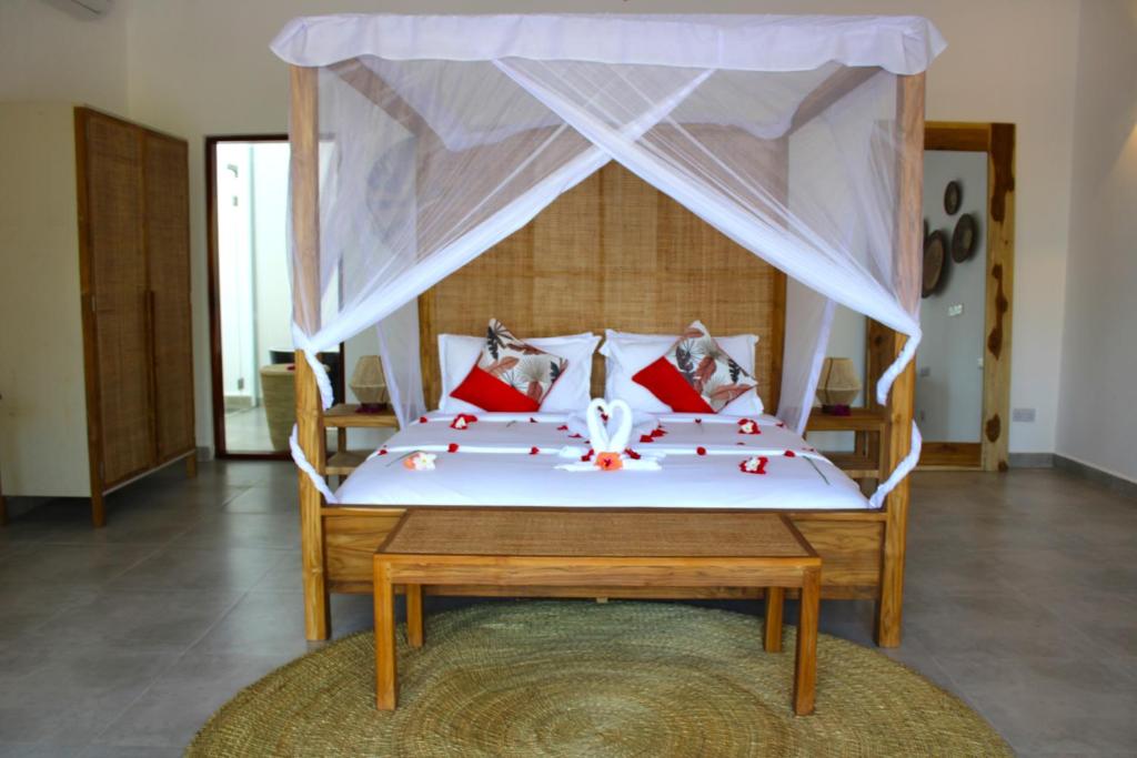 帕杰Kivuli Beach Resort Paje的一间卧室配有一张带红色枕头和天蓬的床