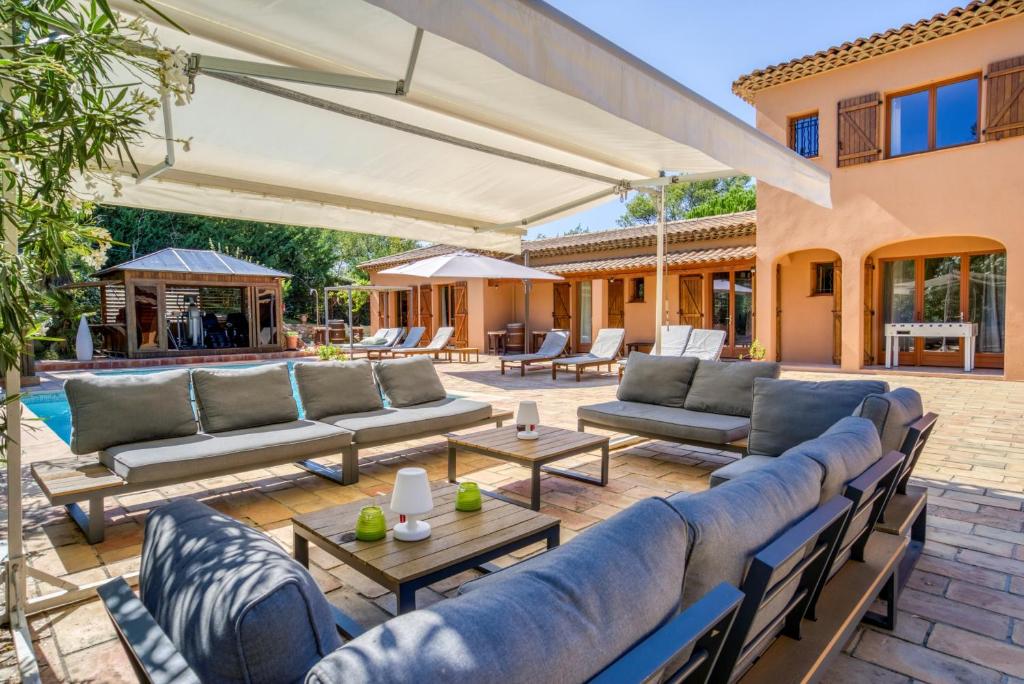 穆昂萨尔图Villa Golf les Cigales的一个带沙发和桌子的户外庭院