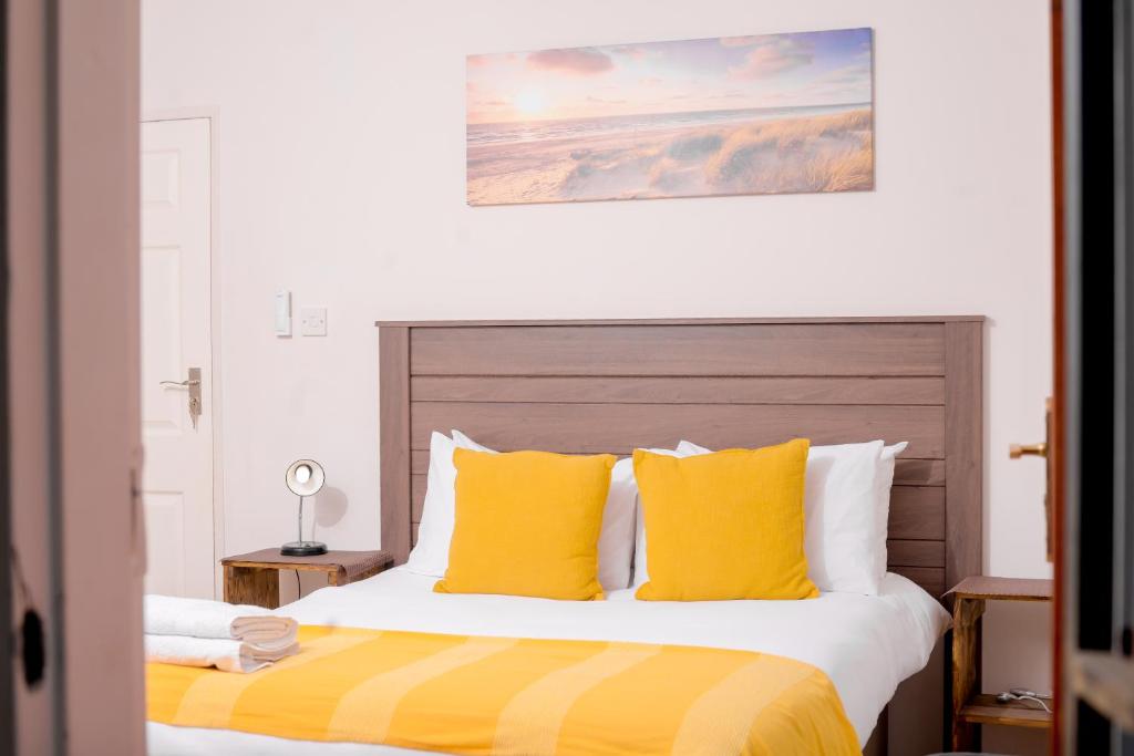 哈博罗内Entire 2 Bed, 5 mins 2 Game City, Netflix & Ps4的一间卧室配有一张带黄色枕头的大床