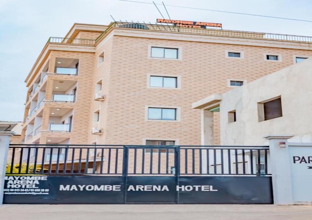 黑角Mayombe Arena Hotel的前面有栅栏的大砖砌建筑
