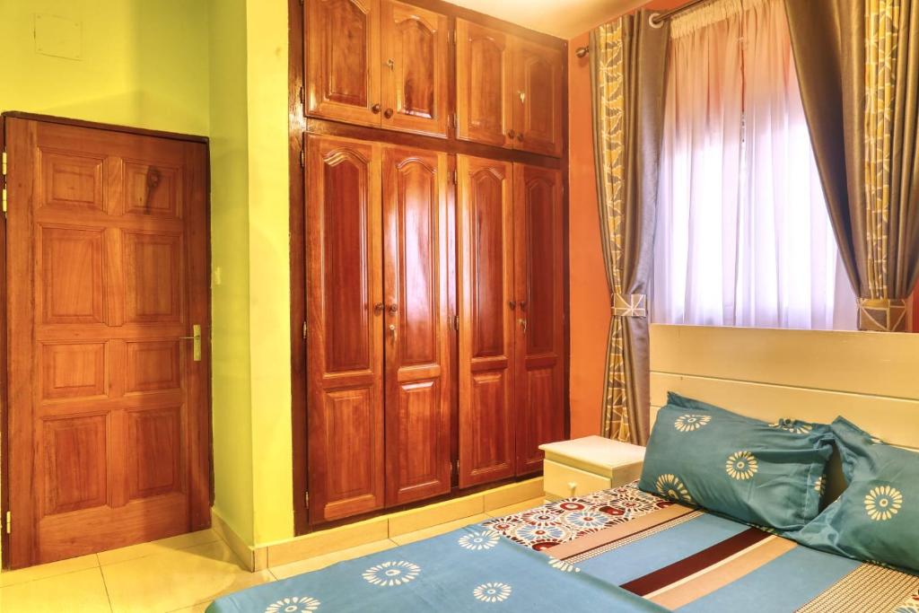 杜阿拉Meuble Modon Nyalla的一间卧室配有一张床和一扇木门