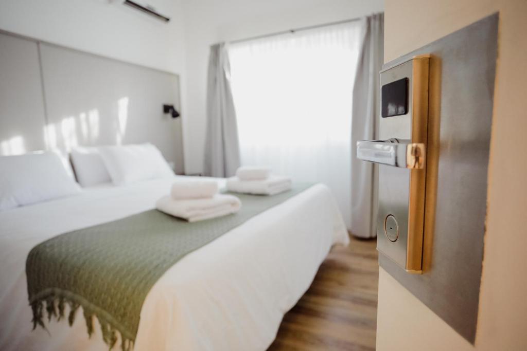 罗卡将军市Hotel Barda Sur的一间卧室配有一张床,上面有两条毛巾