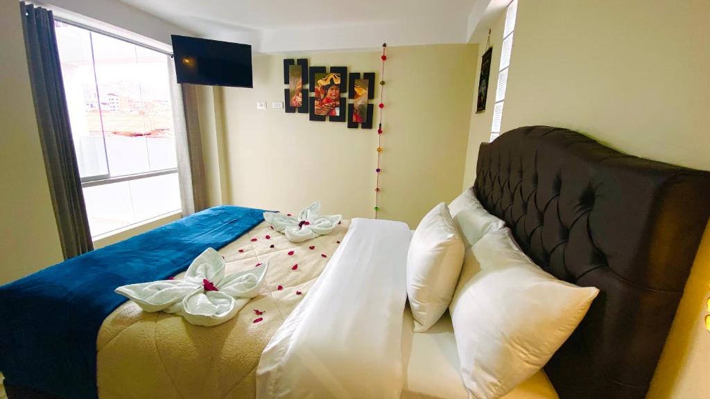 库斯科Hotel Valle Andino的一间卧室,配有一张带弓的床铺