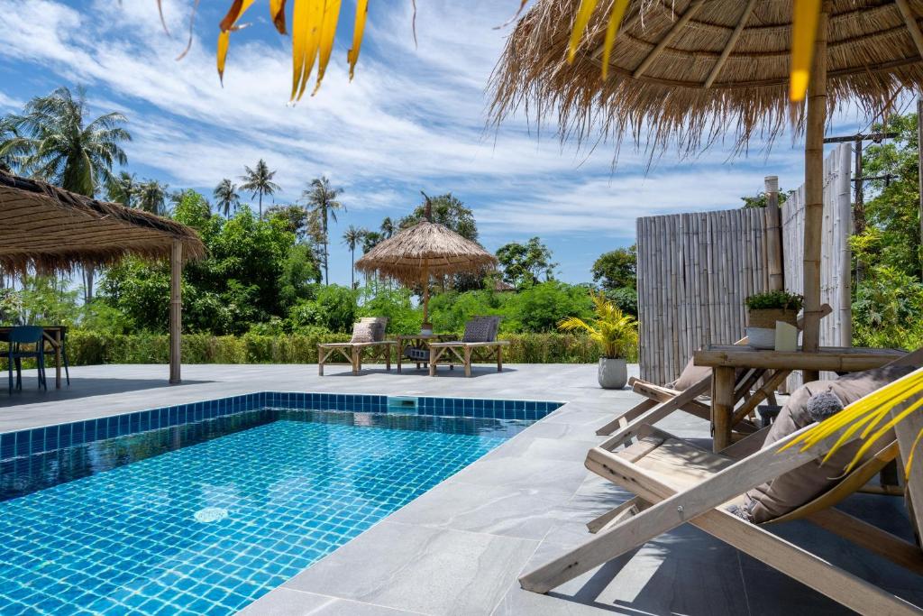 高兰Manao Seaview Pool Villa 20 - 5 Mins Walk To The Beach的毗邻度假酒店的带椅子和遮阳伞的游泳池