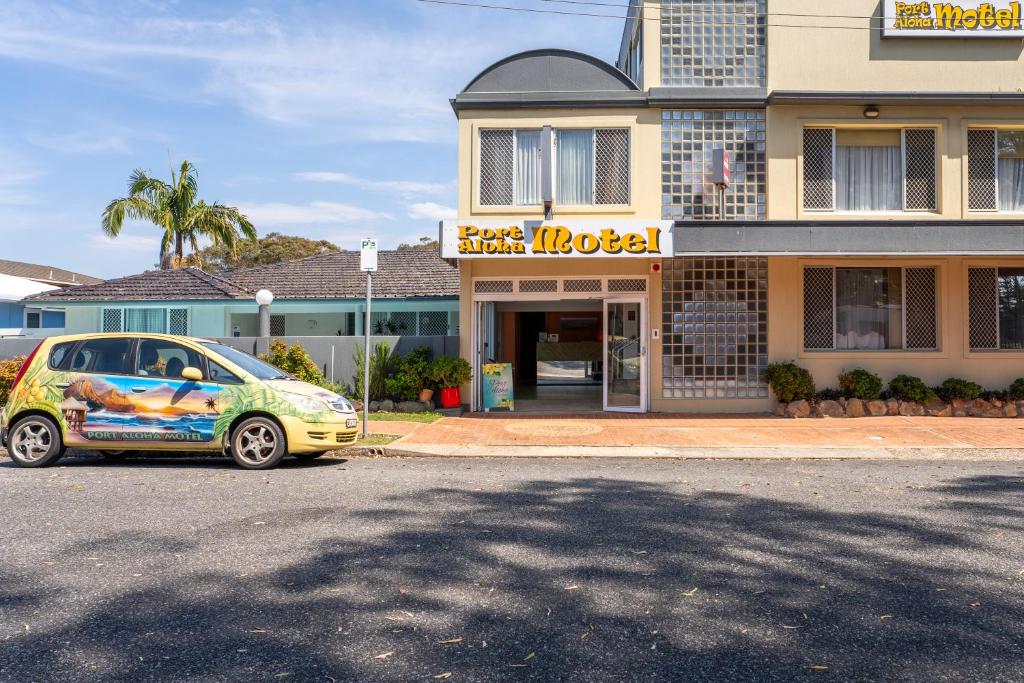 麦夸里港阿罗哈港口汽车旅馆的停在大楼前的小汽车