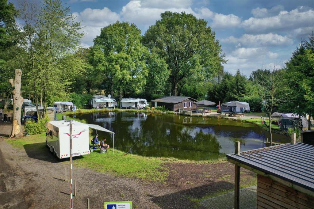 费尔德霍芬Het Denneke的停泊在湖边的有房子的公路