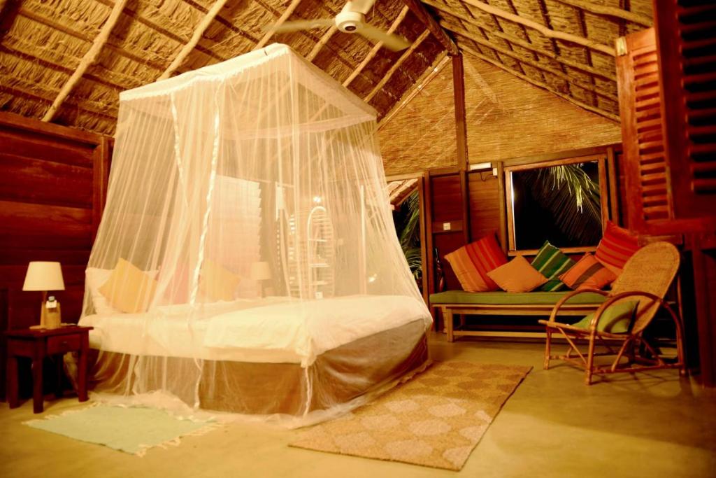 卡尔皮蒂耶Palagama Beach Resort的一间卧室配有一张带蚊帐的床