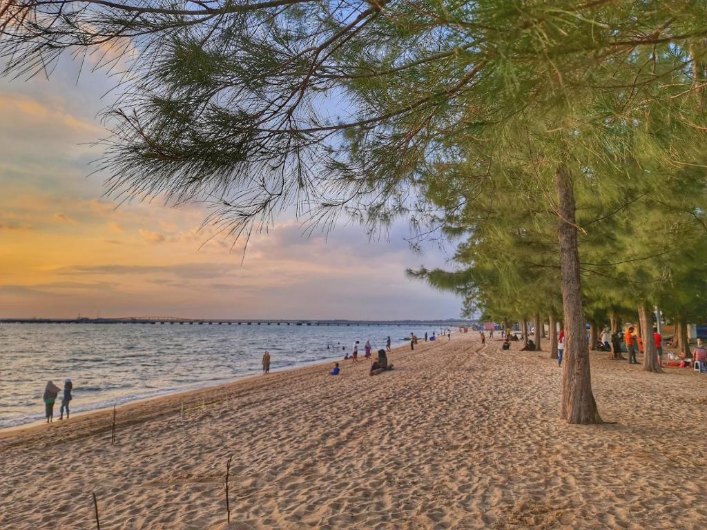 Tangga BatuMutiara Melaka Beach Paradise by Glex的一片海滩上有许多人和树木