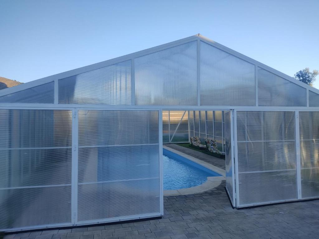 劳哈尔德亚恩达拉斯阿米雷-阿普哈拉家庭乡村酒店的一座玻璃房子,里面设有游泳池