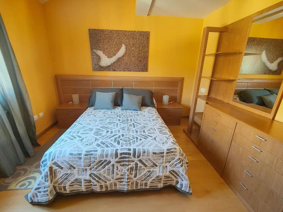 厄尔·布尔戈·德·奥斯马Ático Duplex CALLE MAYOR的一间卧室设有一张床和黄色的墙壁