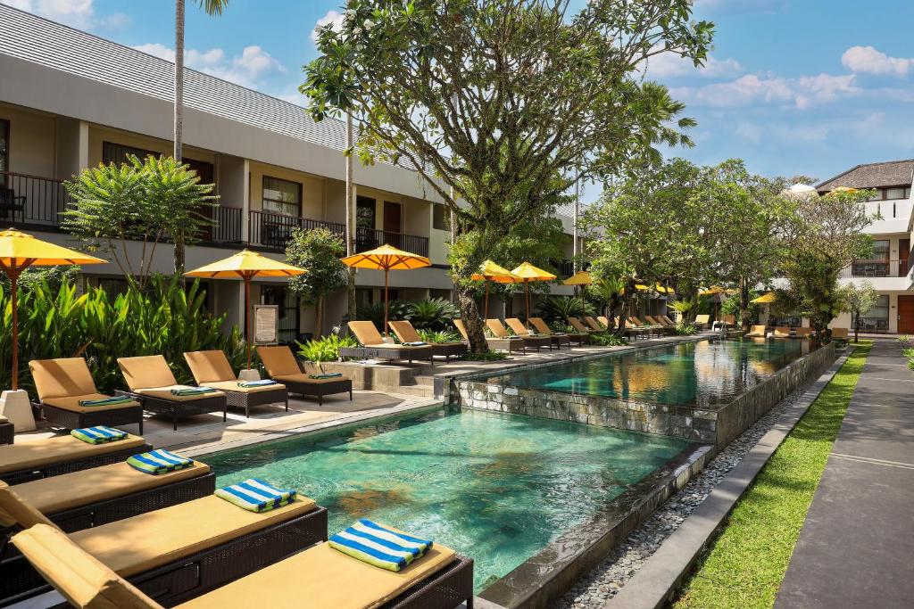 塞米亚克阿玛迪假日别墅酒店的游泳池,带椅子和遮阳伞