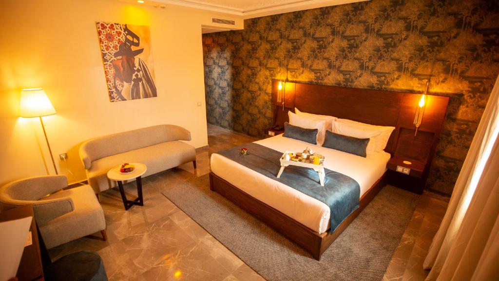 卡萨布兰卡Fourteen Hotel Ain Sebaa的酒店客房,配有床和沙发