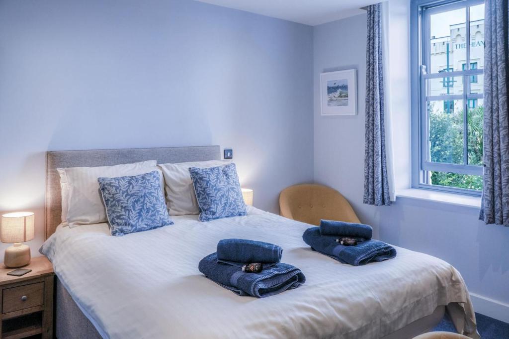 桑德斯富特Ocean Cabins No 4 At The Square - Saundersfoot的一间卧室配有一张带蓝色枕头的床。