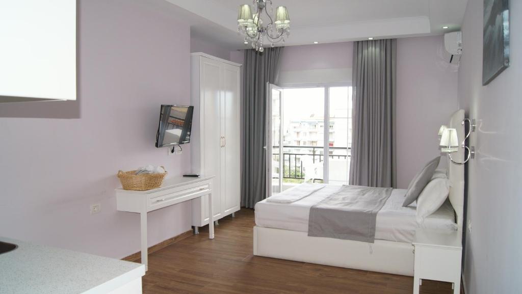 萨兰达Apartments Flower Residence的白色的卧室设有床和窗户