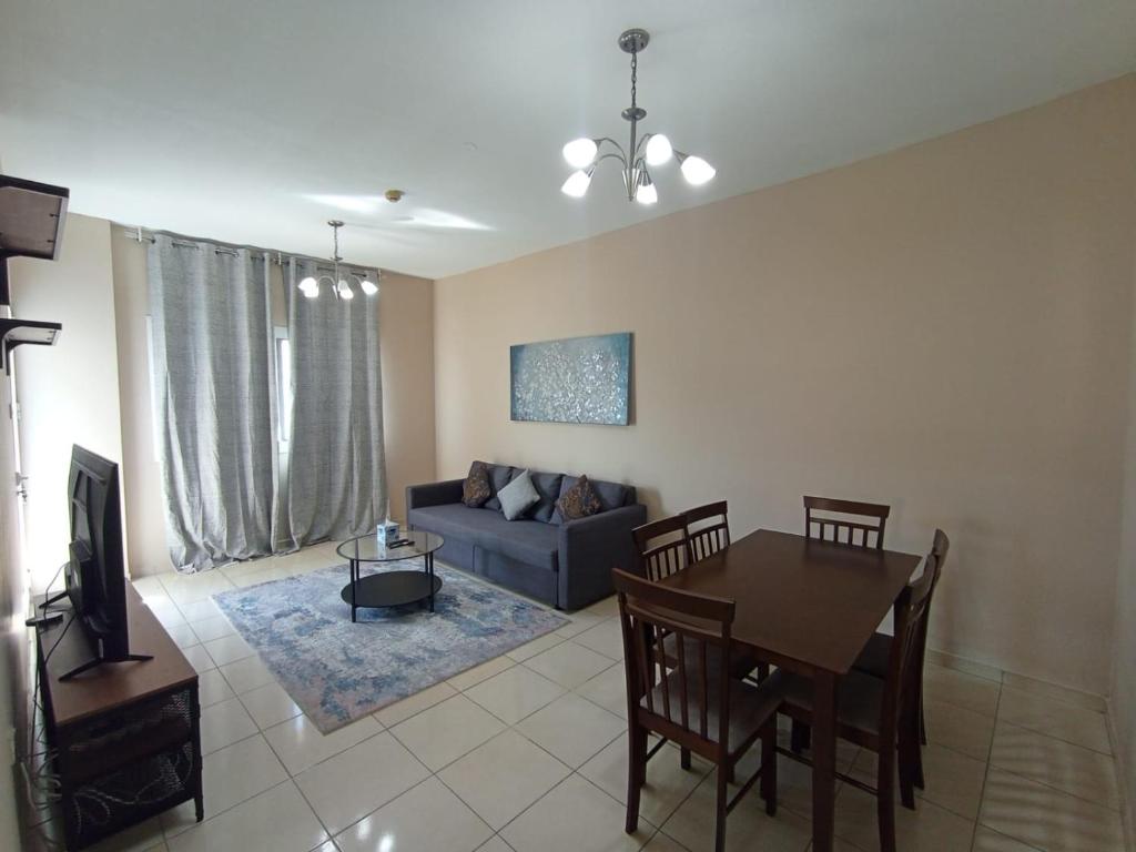 迪拜Marbella Holiday Homes - Al Nahda 2BHK的带沙发和餐桌的客厅
