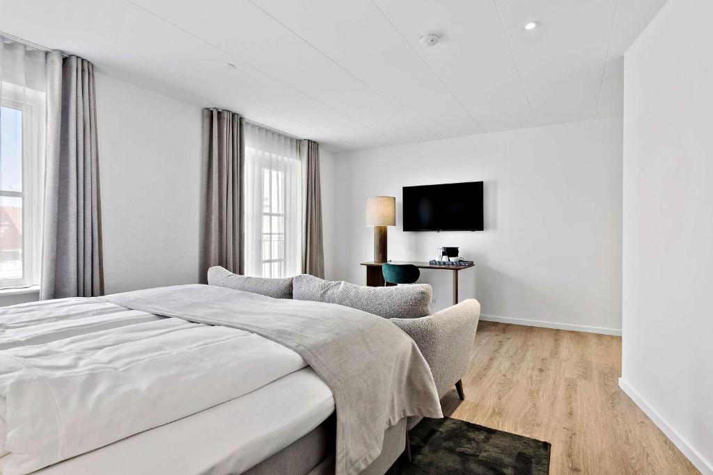 腓特烈港赫尔曼班戈贝斯特韦斯特酒店的白色卧室配有床和椅子