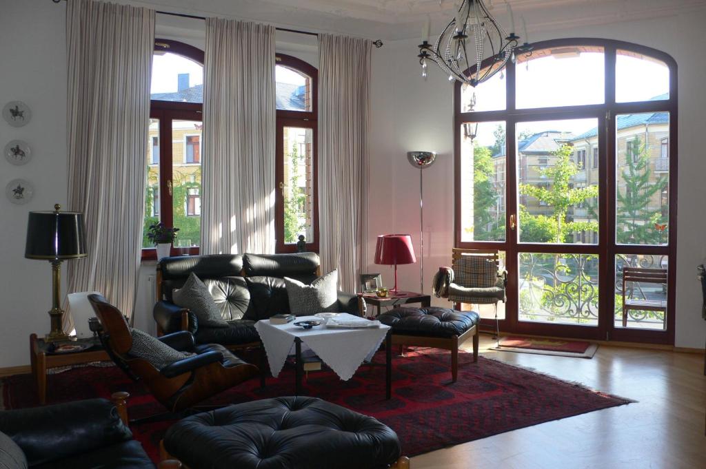 德累斯顿菲德勒别墅公寓的客厅配有皮革家具和大窗户