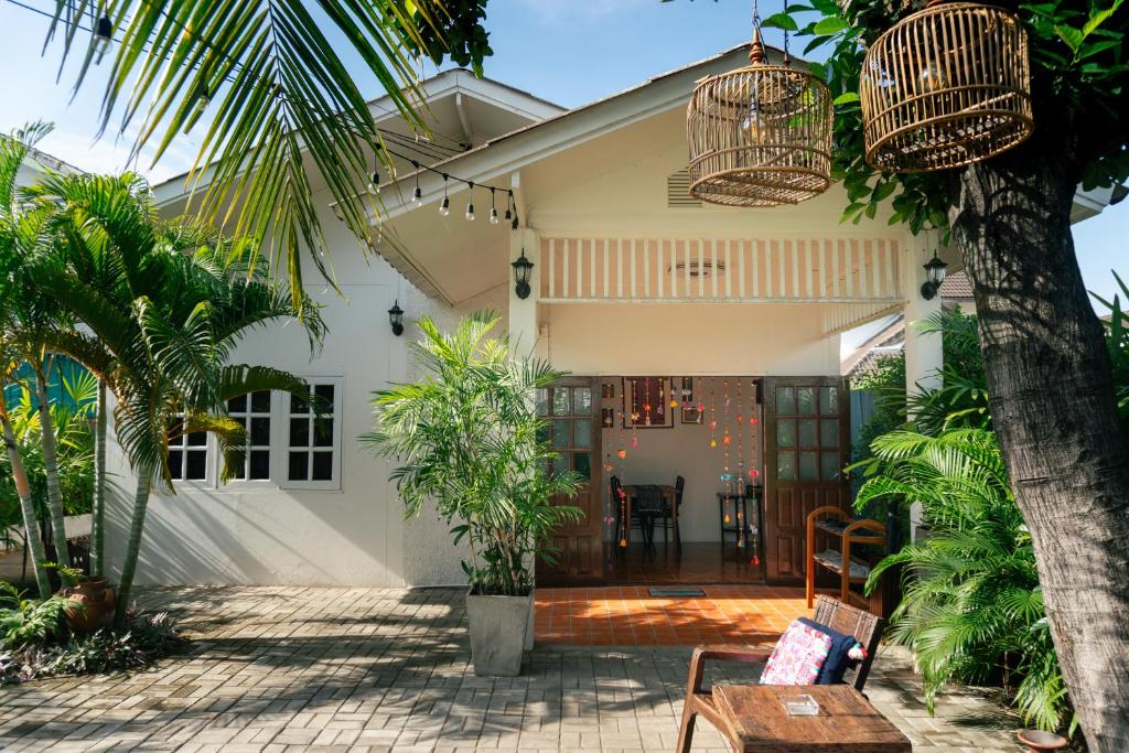 清迈Baan Ragang : Cozy Entire House in Old Chiang Mai的棕榈树和庭院的房子