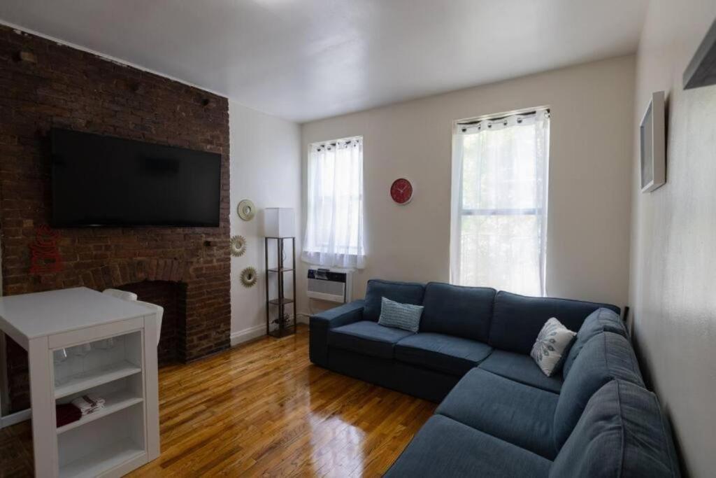 纽约Warm 1-Bedroom Apt in Manhattan的客厅设有蓝色的沙发和壁炉