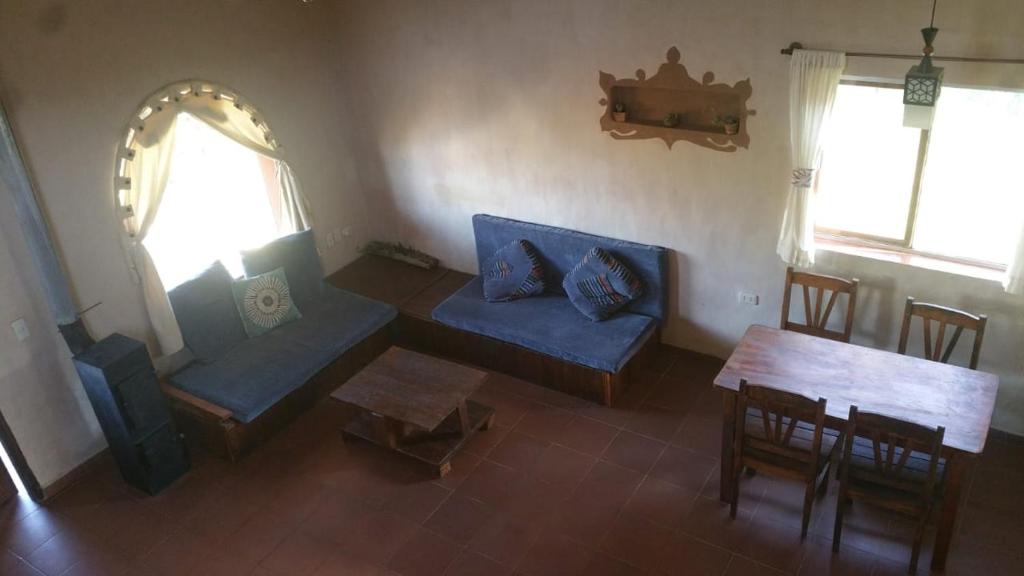 萨迈帕塔Casa Amanecer的客厅配有蓝色的沙发和桌子