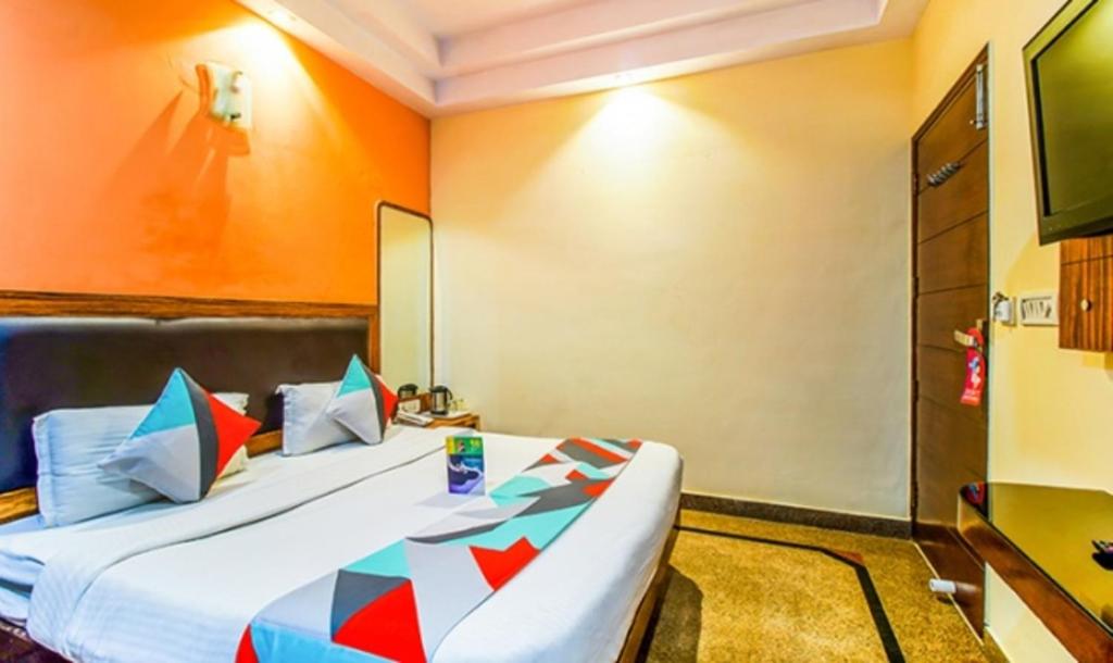 新德里FabExpress JP Palace的一间酒店客房,配有一张床和一台电视