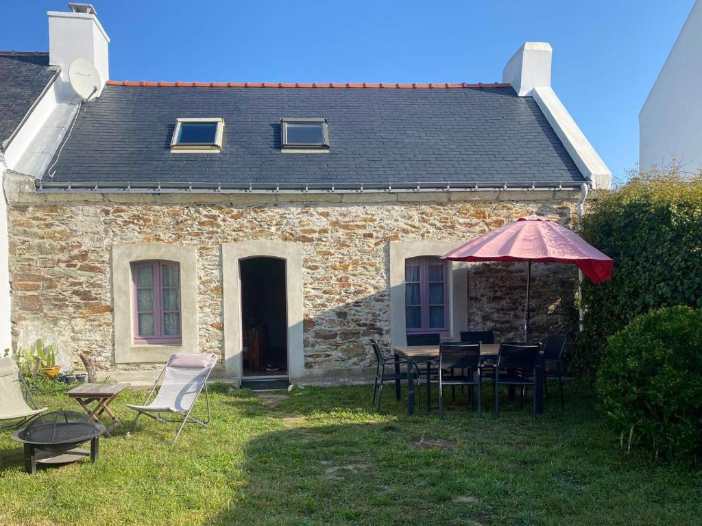 班戈Charmante maison en pierre avec jardin à Bangor, à 1500 m de la plage de Vazen - FR-1-418-157的房屋配有桌椅和遮阳伞